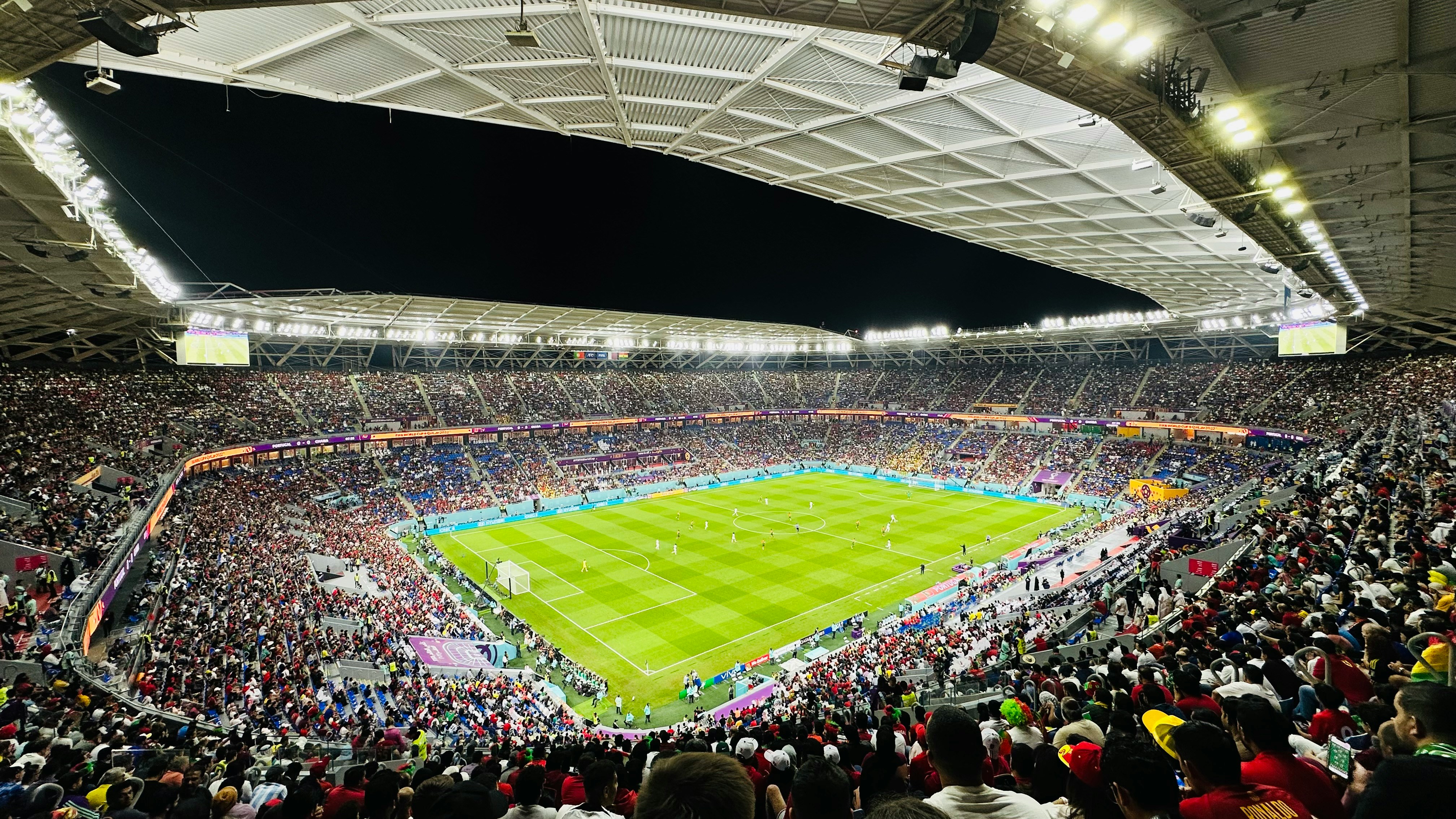 Crowd watching a FIFA World Cup 2026 match on a big screen at an outdoor fan zone