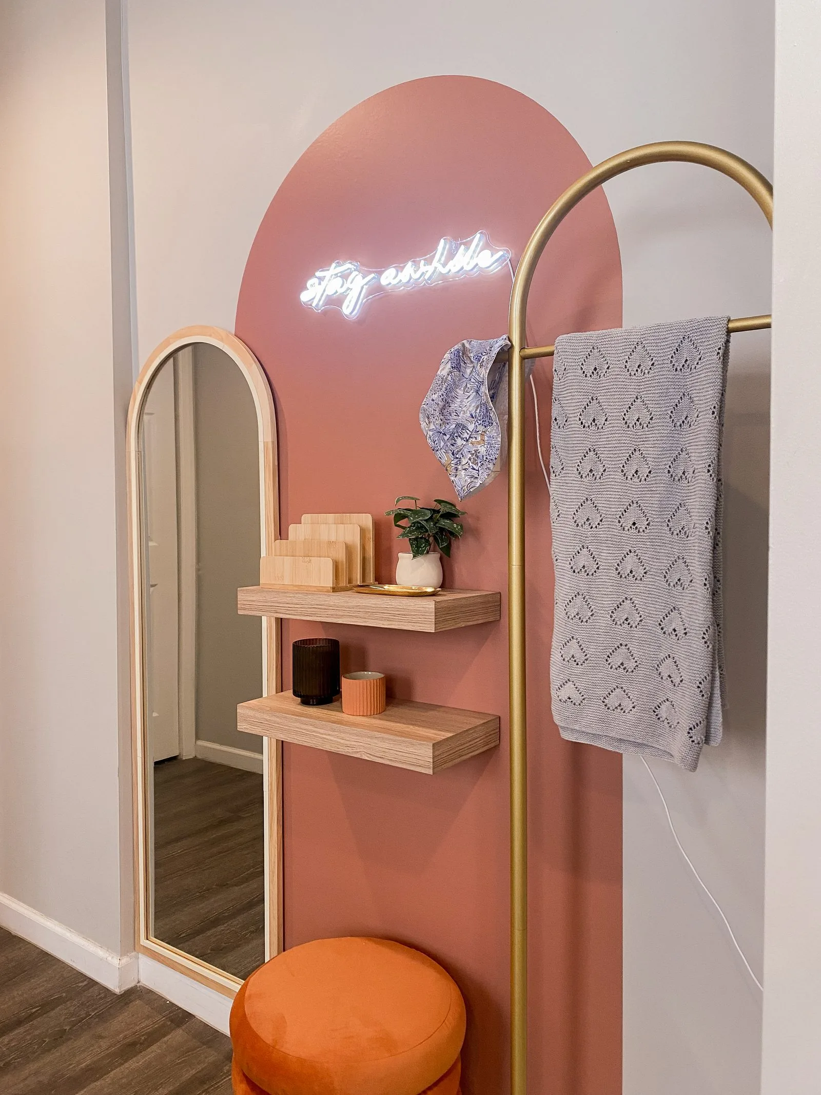 Entryway — "Stay Awhile" neon on rose arch, arched mirror