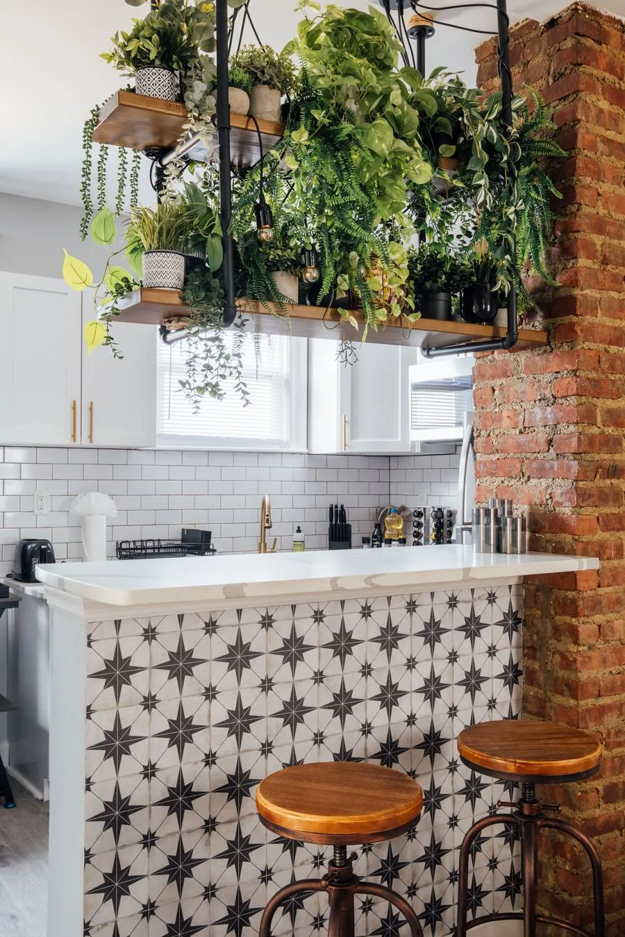 Hanging plant installation over star-tile kitchen bar with exposed brick