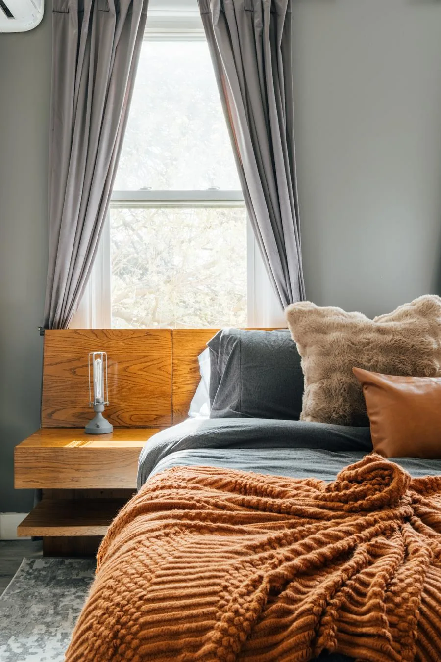 Second bedroom with orange accent wall and art mural