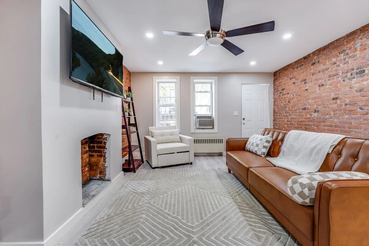 City Oasis living room with exposed brick and leather sofa
