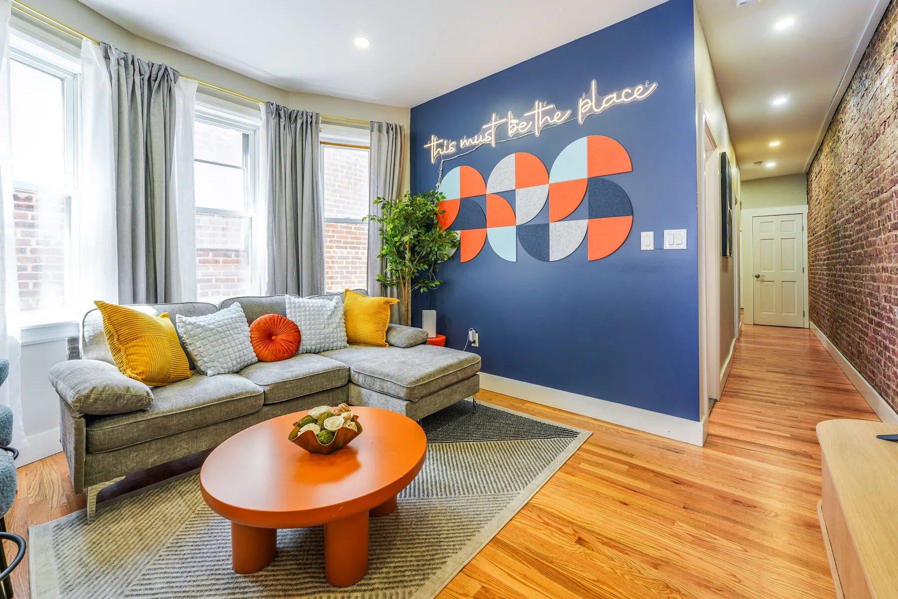Color Burst living room with neon sign and bold mural wall