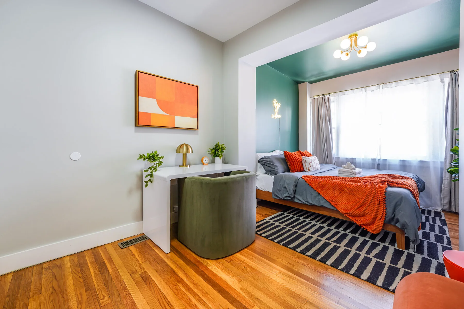 King bedroom with teal accent wall and neon sign