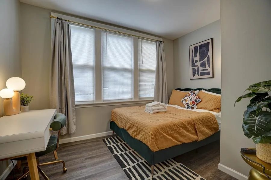 Primary bedroom - teal velvet headboard with ochre bedding