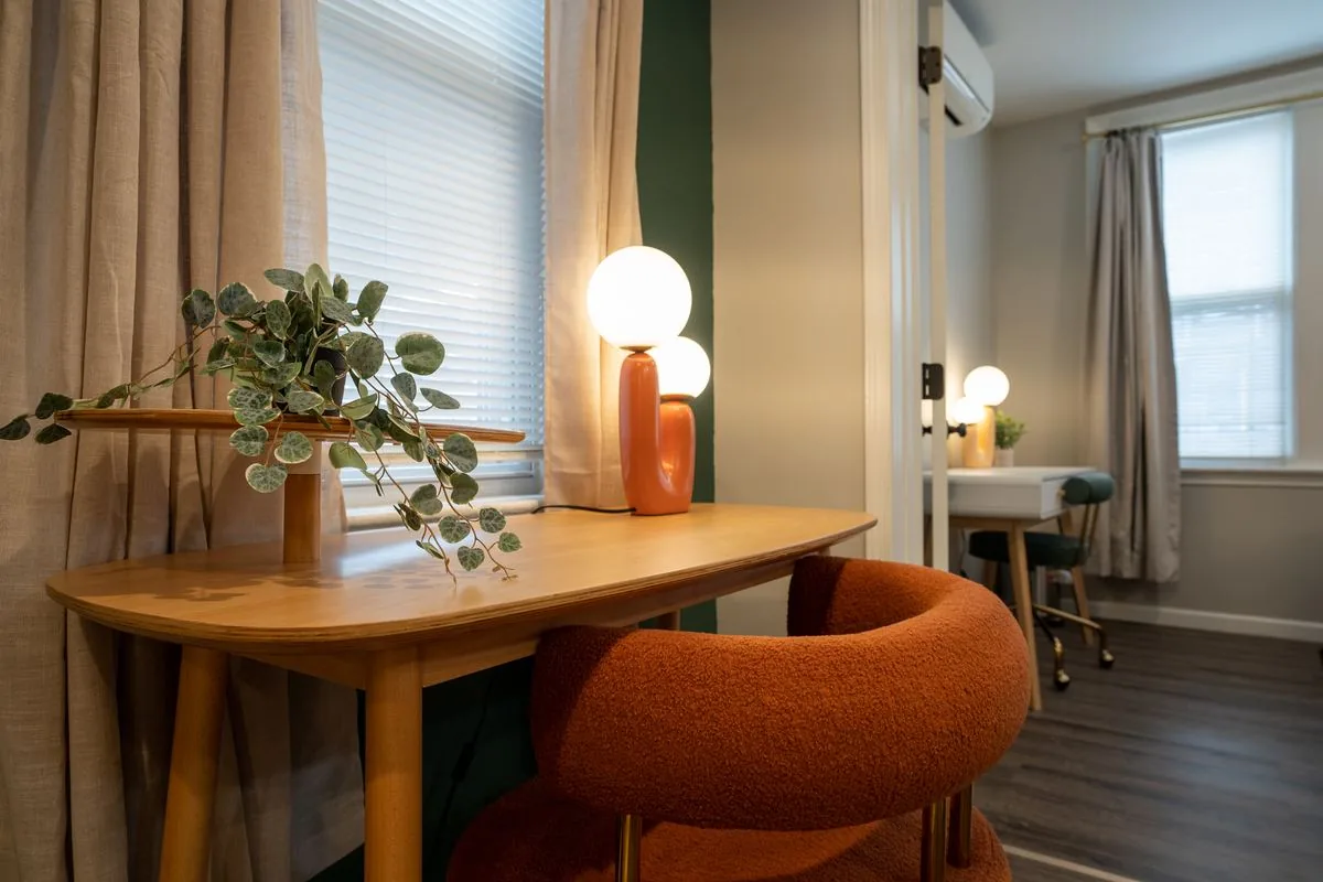 Dining nook with orange bouclé chair and globe lamp