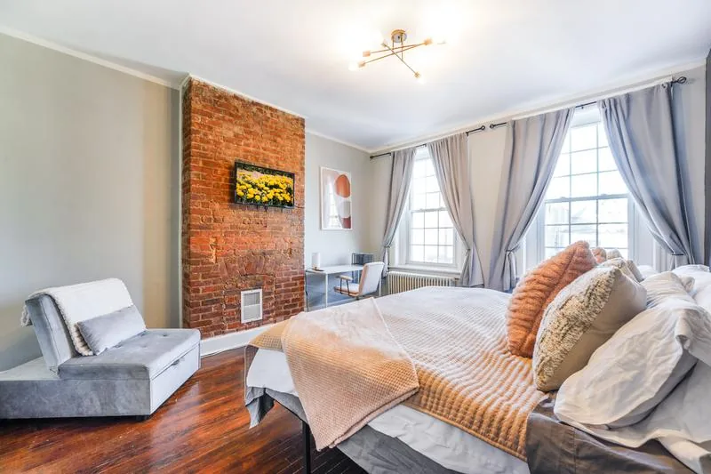 Bedroom with exposed brick accent wall and queen bed